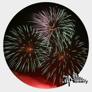 Red and green fireworks light the night sky, showcasing a fireworks sound effects library image for Sonniss by Noisery.