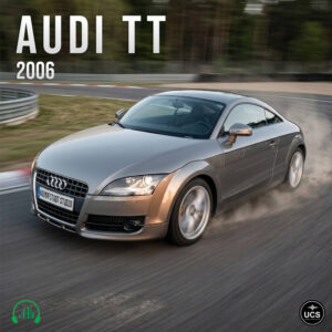 Silver 2006 Audi TT sports car drives around a racetrack curve with visible motion blur.