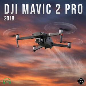 A grey DJI Mavic 2 Pro 2018 UAD drone quadcopter flies against a sunset sky.