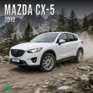 White 2012 Mazda CX-5 compact crossover SUV driving on a dirt road with mountains in the background.