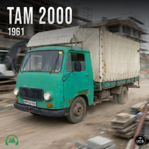 Green vintage TAM 2000 1961 truck with a white canvas cover drives across a dirt construction site.