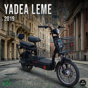Black Yadea Leme 2019 electric scooter with a front wire basket and two seats parked on cobbled streets.